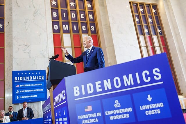 BIden at a lectern surrounded by signage on Bidenomics.