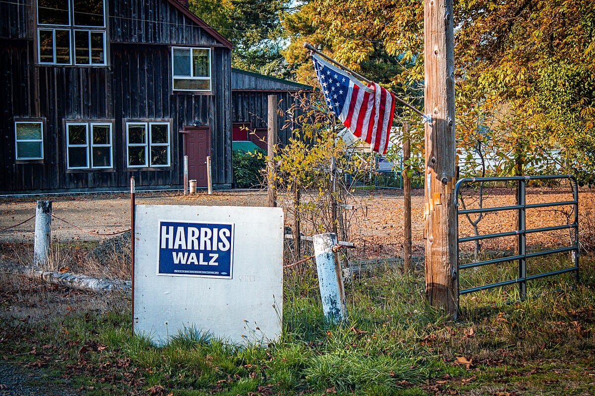 A Harris-Walz sign underneath an American flag outside a home in Blachly, Oregon.